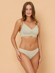Fototapeta premium Girl model in underwear posing in studio on beige background.