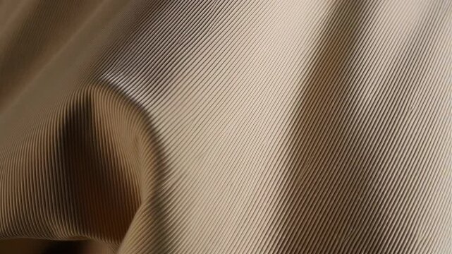 Abstract ribbed beige fabric with light and shadow, pleated textile surface, soft neutral color fashion design element, draped material backdrop