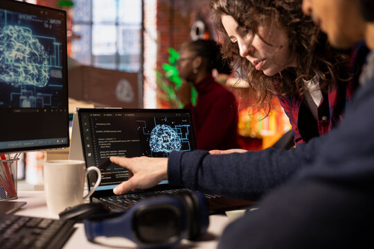 Coworkers doing brainstorming in AI tech agency providing software development services. Close up of startup office colleagues cooperating, using artificial intelligence to streamline coding process - Powered by Adobe