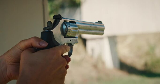 Close-up of a person holding a revolver ready to fire at shooting range