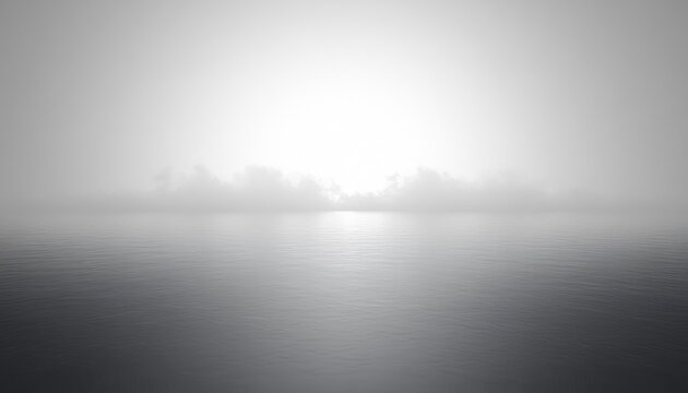 Calm sea at dawn with soft mist above the water and a gentle brightening sky creating a peaceful and serene atmosphere