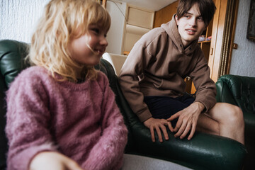 Fototapeta premium Two young individuals enjoying a cozy moment together in a living room during a casual afternoon