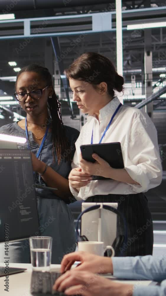 Poster vertical video software developers working together in server farm, reviewing neural network code an