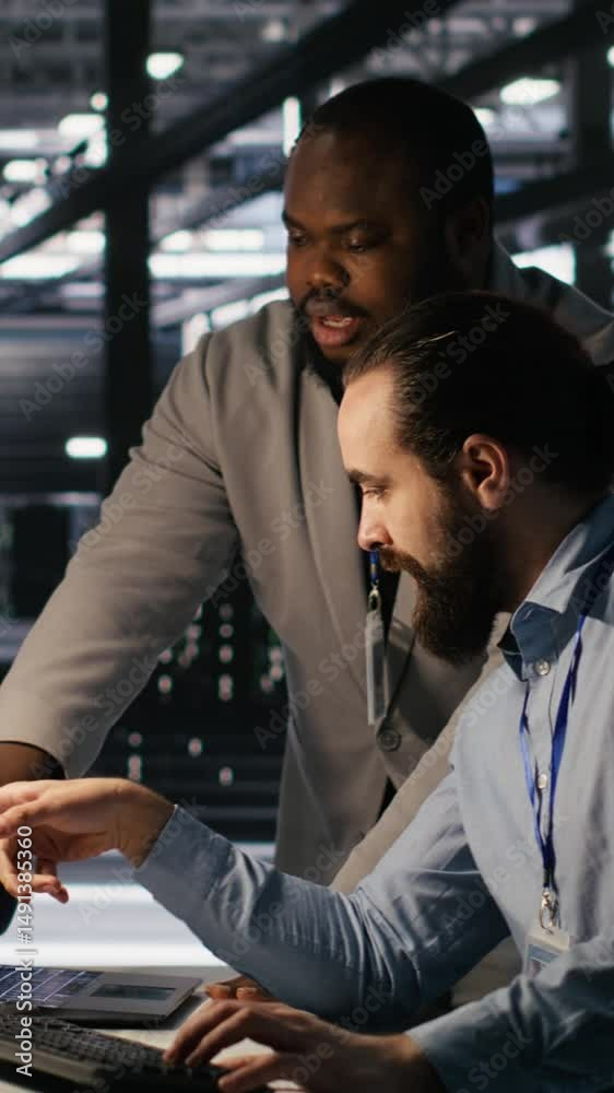 Poster vertical video data center engineers use laptop, collaborating on doing ai software updates. server 