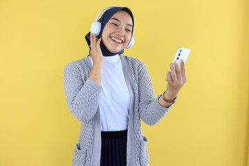 Young Muslim Girl Playing Music on Her Phone and Hearing with Headphone