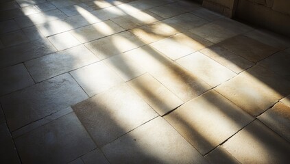 Sunlight streams through unseen windows, casting long, vertical shadows across a light beige, stone-like tiled floor. The tiles are irregularly sized and subtly textured