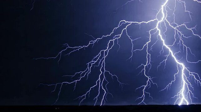 Vivid purple lightning strike illuminating the darkness, a dramatic electrical discharge arcing across a pure black background, creating a powerful and energetic visual effect for various projects.