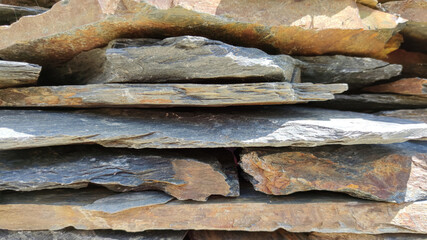 Background and texture of a wall made of rough natural stone. Stone facade cladding.