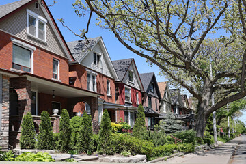 Tree lined street with old brick houses with gables