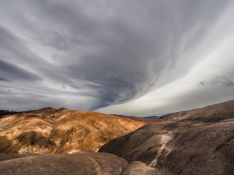 Massive shelf cloud looming over the orange rhyolite mountains of Kerlingarfjoll, Iceland highlands