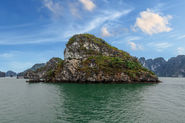 Fototapeta premium Halong Ha Long Bay Hanoi this Vietnamese wonder is littered with mountains and Rock cliffs popping out of the ocean, lush green mountains colourful skies in Vietnam