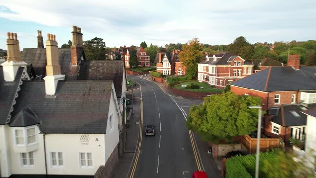  Low angle tracking a Car driving on residencial street, row of buildings early morning