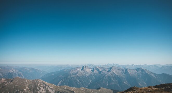 Breathtaking panoramic view of a vast mountain range under a clear blue sky
