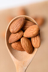 Raw almond nut seed in wooden spoon, Top view
