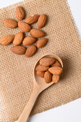 Raw almond nut seed in wooden spoon, Top view