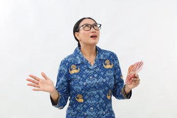 Surprised amazed young civil servant woman holding Indonesia banknotes while looking above