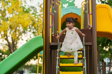 happy toddler girl playing at a outdoor playground in park