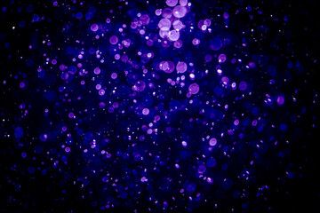 Blurred photo with purple violet and blue dots visible glittering, shining brightly look and feel luxurious