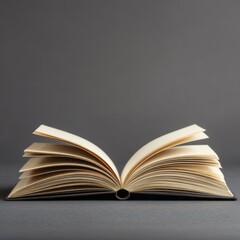 Fototapeta premium Open book on gray background close up studio shot education knowledge reading studying learning literature library