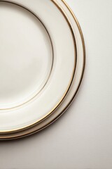 Elegant Ivory Plates with Gold Trim Stacked on Textured White Surface Close Up Studio Shot