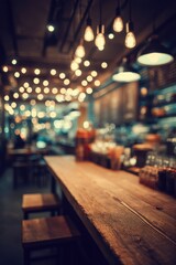 Rustic wooden counter and stools in a warm inviting cafe with blurred background lights and menu board in soft focus