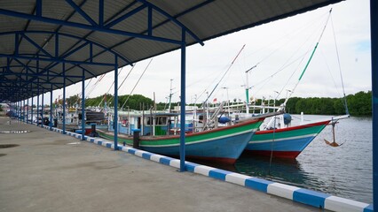 Traditional fishing boats with colorful paint docked at a bustling harbor, showcasing vibrant hues and maritime equipment. Ideal for commercial use in travel, culture, and lifestyle themes