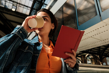 Young woman enjoying coffee while reading book