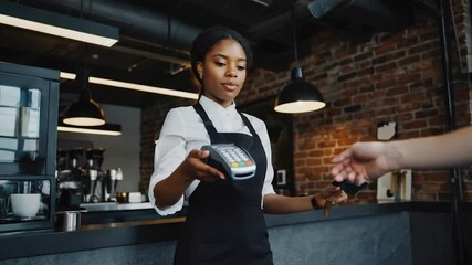 Barista taking payment at modern coffee shop