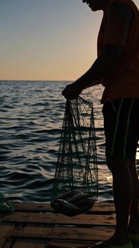 Elderly fishers with their catch by the sea
