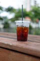 Close up ice black coffee on the wooden table after drink.