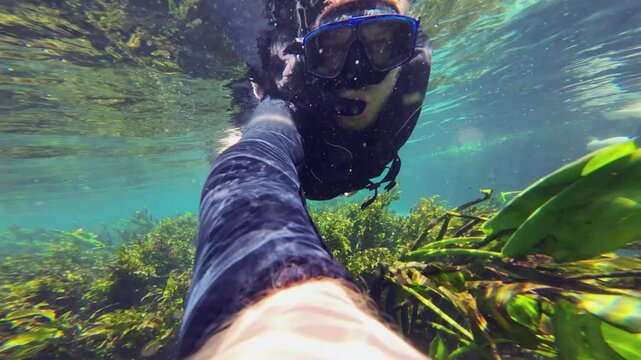 Underwater selfie: Man snorkelling in shallow clear river current