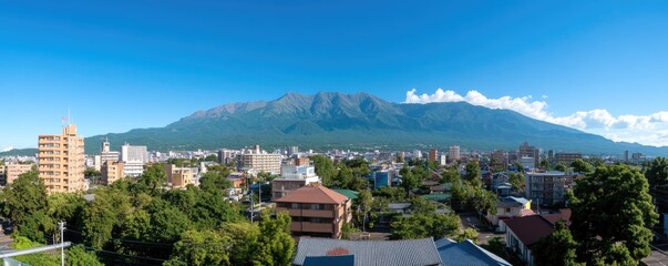 Cityscape panorama with mountain backdrop under a bright blue sky