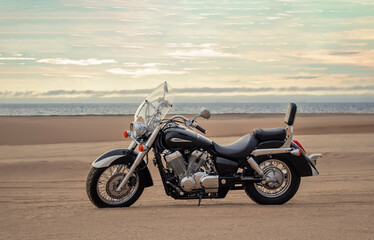 "Motorcycle in Sandy Desert at Sunset with Dramatic Cloudy Sky and Warm Soft Light