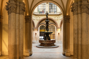 Vienna – View of the Ferstel Passage fountain, the elegant Renaissance Revival bronze sculpture surrounded by the arcade's ornate ironwork and glass-domed ceiling, creating a jewel-like centerpiece.