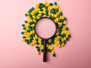 Top view medicine pill and magnifying glass on a pink background