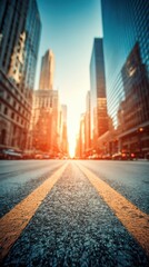 Obraz premium Urban avenue perspective looking toward bright sun between skyscrapers in city center at sunrise or sunset