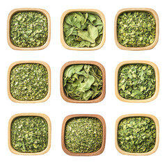 Dried herbs in wooden bowls whole and chopped leaves culinary ingredients