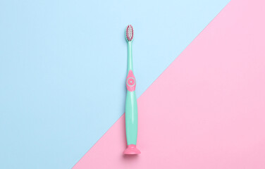 Children's plastic toothbrush on pink blue background