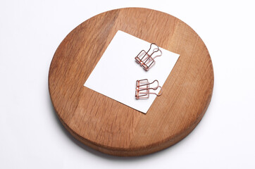 Memo white square sheet of paper with binder clip on round wooden board
