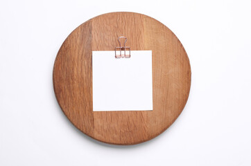 Memo white square sheet of paper with binder clip on round wooden board