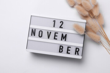 12 november letterboard text on Lightbox with dry lagurus flowers, white background. Seasonal...