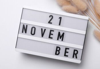 21 november letterboard text on Lightbox with dry lagurus flowers, white background. Seasonal...