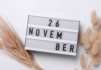 26 november letterboard text on Lightbox with dry lagurus flowers, white background. Seasonal calendar. Flat lay. Top view