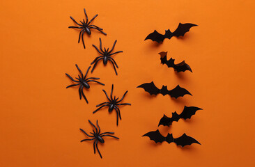 Halloween decoration spiders and bats on orange background