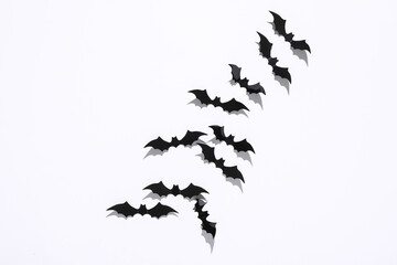 Halloween decoration concept. Black paper bats flying on white background. Top view