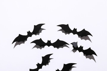 Halloween decoration concept. Black paper bats flying on white background. Top view