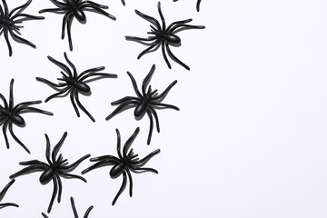 Halloween pattern with plastic spiders on white background
