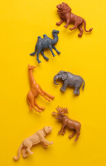 Toy zoo, set of wild animals on yellow background. Top view