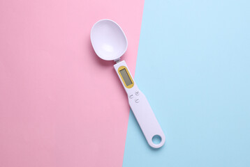 Spoon scales on blue pink background. Modern gadgets
