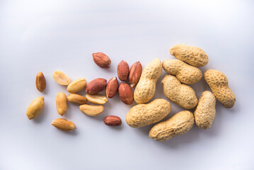 Organic peanuts a collection of whole peanuts in their shells and a few without shells,healthy snacking concept with peanuts rich in protein, isolated on white background.